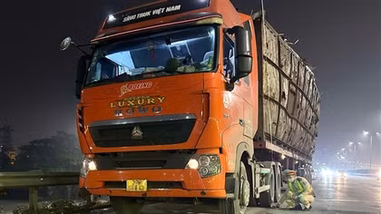 Xe đầu kéo chở hàng cao ngất ngưởng, ngả nghiêng đi ra đường