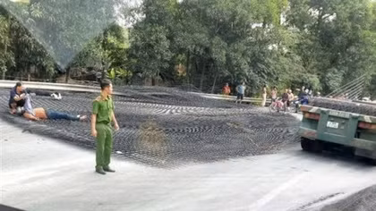 Hàng tấn thép lưới rơi từ xe đầu kéo xuống đường đè 2 người đi xe máy