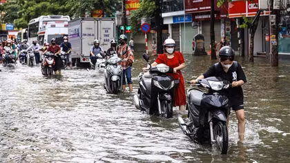 Đường phố Hà Nội vẫn ngập sâu sau mưa lớn, người dân dắt xe máy qua "biển nước"