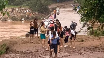 Xúc động hình ảnh thầy hiệu trưởng cùng giáo viên cõng học sinh vượt bùn đất để tới trường