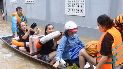 Công an lội nước đẩy thuyền giúp người dân thoát khỏi vùng ngập lụt nguy hiểm