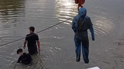 Mặc áo chống dịch cho thi thể nạn nhân trước khi đưa lên bờ