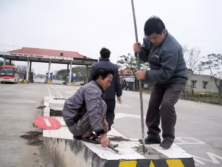 Rét cắt da cắt thịt nhưng những công nhân vẫn đứng chôn biển báo ở trạm thu phí cầu Gianh vì "nhớ trạm và tạo thuận lợi cho xe đi lại".