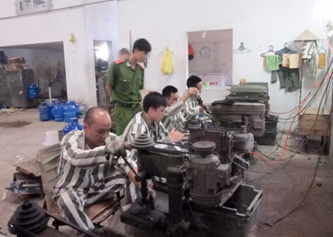 Quản giáo Đỗ Thế Tuân đang thao tác kỹ thuật cho phạm nhân mới vào cải tạo ở xưởng cơ khí.