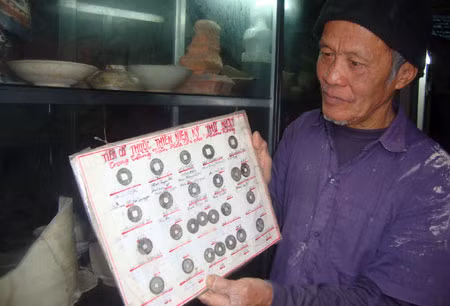 Nghệ nhân Nguyễn Việt Hồng với bộ sưu tầm tiền cổ.