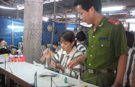 Cán bộ quản giáo dạy nghề cho phạm nhân nư.