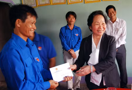 Phó Chủ tịch nước Nguyễn Thị Doan trao quà cho đoàn viên Trần Thanh Thành, người đã sáng chế ra máy phát điện chạy bằng sức gió dùng cho hộ gia đình. Ảnh: TTXVN.