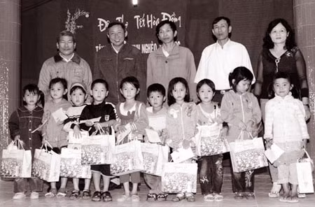 Thầy giáo Cao Trung (đứng giữa, hàng sau) tặng quà cho học sinh nghèo hiếu học trong đêm thơ truyền thống Hòa Đồng.
