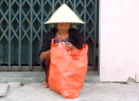 Người mẹ sau một ngày bán bánh nậm đếm từng đồng tiền lẻ để lo cho gia đình.
