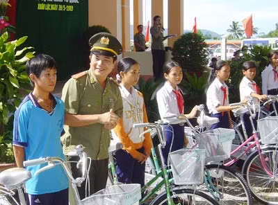 Đại tá Ngô Minh Đức, Phó giám đốc Công an tỉnh Đồng Nai tặng xe đạp cho học sinh nghèo người dân tộc thiểu số ở huyện Xuân Lộc.