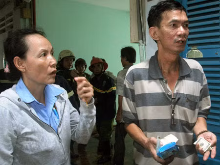 Vợ chồng ông Châu nhận lại số tiền đô từ các chiến sĩ chữa cháy.
