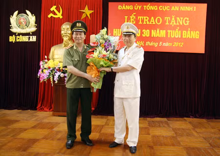 Thượng tướng Trần Đại Quang, Ủy viên Bộ Chính trị, Bí thư Đảng ủy Công an Trung ương, Bộ trưởng Bộ Công an tặng hoa chúc mừng Trung tướng Tô Lâm, Ủy viên Trung ương Đảng, Thứ trưởng Bộ Công an được tặng Huy hiệu 30 năm tuổi Đảng. Ảnh: Việt Hưng.