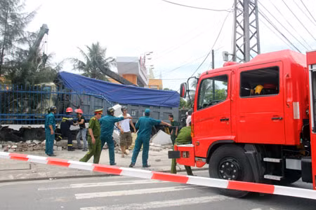 Dùng tời kéo sập cổng bên hông doanh trại tạo mặt bằng thoáng cho công tác cứu hộ.