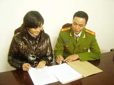 Trung tá Dũng đang trao đổi công việc với đồng nghiệp trẻ.