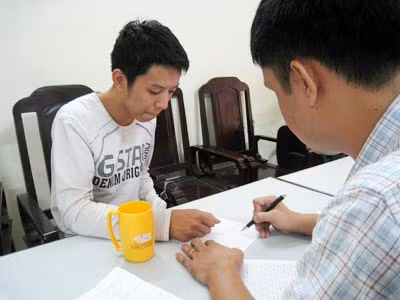 Nguyễn Hoàng Anh (bên trái) tại Cơ quan Điều tra.