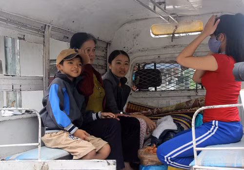 Một gia đình được lực lượng Công an di chuyển đi tránh bão.