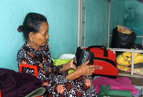 Một người dân tránh bão đang theo dõi dự báo thời tiết qua chương trình phát thanh của Đài tiếng nói Việt Nam.