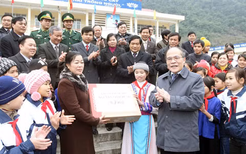 Chủ tịch Quốc hội Nguyễn Sinh Hùng tặng quà cho Trường Trung học cơ sở Pác Bó, xã Trường Hà. Ảnh: TTXVN.