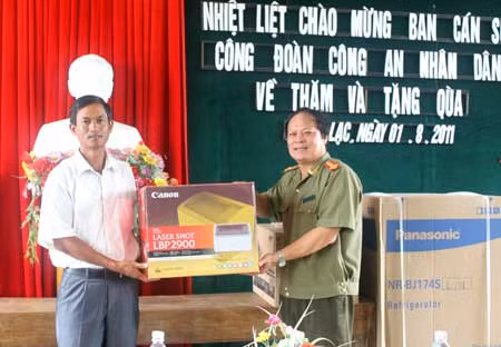 Đại tá Nguyễn Văn Pháp, Phó Cục trưởng, Trưởng Ban Cán sự Công đoàn CAND trao quà cho lãnh đạo UBND xã Thanh Lạc.