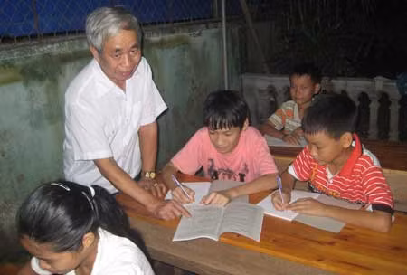 Ông Nguyễn Hữu Khi đang giảng bài cho học sinh nghèo.
