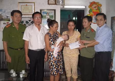 Đại tá Lưu Vinh, Phó Tổng biên tập Báo CAND cùng vợ chồng ông Lâm Tấn Lợi trao tiền hỗ trợ gia đình cháu Vũ Hà Linh.