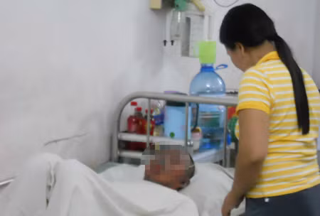 Thu nằm đau đớn trên giường bệnh. Bạn trai đang chăm sóc Thu.
