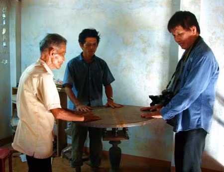 Chủ và khách cùng trải nghiệm với chiếc bàn cổ tự xoay tại nhà ông Trần Ngọc Tuấn.