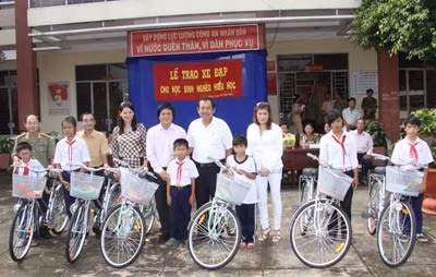 Đồng chí Trương Hoà Bình - Uỷ viên Trung ương Đảng, Chánh án TAND tối cao và các "mạnh thường quân" trao xe đạp cho các học sinh tiểu học huyện Đức Hoà, tỉnh Long An.