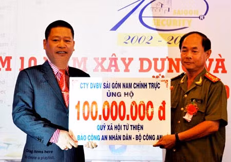 Tổng Giám đốc Sài Gòn Security, ông Phạm Chí Điện trao tượng trưng 100 triệu đồng cho Đại tá Trần Kim Thẩm, Phó TBT Báo CAND.