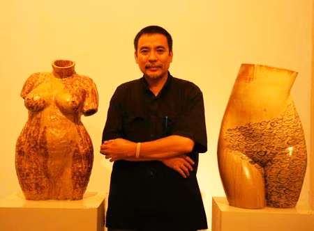 Họa sĩ Nguyễn Khắc Quân bên tác phẩm của mình.