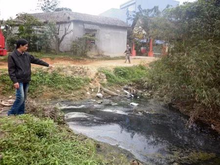 Nguồn nước đen kịt tại con mương nằm sau cơ sở sản xuất bò khô thải trực tiếp ra hồ điều hòa.