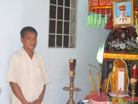 Ông Lương Văn Thế đứng trước quan tài con trai mình.