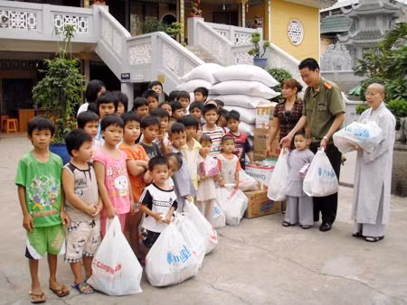 Thượng tá Nguyễn Xuân Xe – Phó trưởng Cơ quan đại diện Báo CAND tặng quà bà con nghèo ở xã Long Trạch và Trung tâm nuôi dưỡng trẻ mồ côi Diệu Giác.