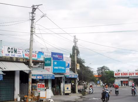 Nhiều vị trí cột điện tại ngã 3 cầu Bà Di, xã Phước Lộc (huyện Tuy Phước), bị vướng vào nhà dân chưa di dời được.