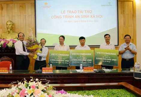 Ông Mai Tiến Dũng - Ủy viên Trung ương Đảng - Chủ tịch UBND tỉnh Hà Nam (ngoài cùng, bên trái) tặng hoa cảm ơn Chủ tịch HĐQT Vietcombank Nguyễn Hòa Bình đã trao số tiền tài trợ xây trường học cho các địa phương của tỉnh Hà Nam.