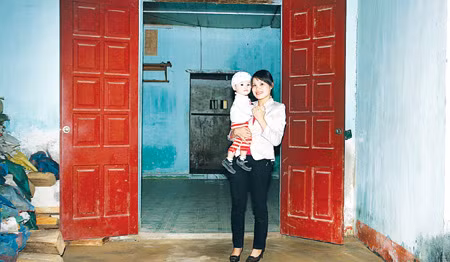 Mẹ con chị Hà Thị Thủy trước ngôi nhà mới.