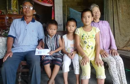 Các thành viên trong gia đình cháu Hà nhận tiền do bạn đọc Báo CAND ủng hộ.