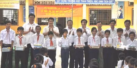 Đại diện Báo CAND, Công ty TNHH Huỳnh Thiên, Sở GD&ĐT tặng quà cho các học sinh nghèo Trường Tiểu học Thới Đông 2.