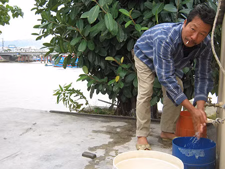Ông Nguyễn Văn Hưng, đang rửa tay từ bể nước trên ốc đảo.