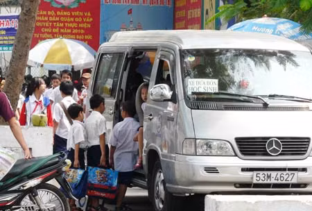 Học sinh bán trú “vệ tinh” được xe đưa rước về cơ sở sau giờ học buổi sáng (ảnh chụp trước cổng Trường Tiểu học An Hội - Gò Vấp trưa 17/2).