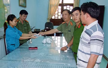 Lãnh đạo Phòng Công tác chính trị cùng 2 đồng chí Nam và Toản trả lại tiền bị mất cho chị Hạnh.