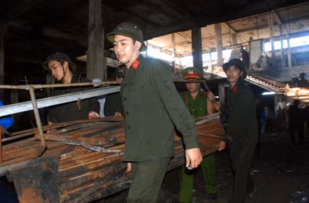 Hàng trăm chiến sĩ di chuyển các vận dụng sắt, thép, tôn nặng giúp tiểu thương tìm kiếm.