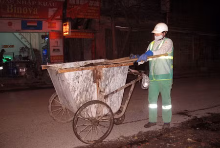 Chị Yến cần mẫn dọn rác trong đêm giao thừa.