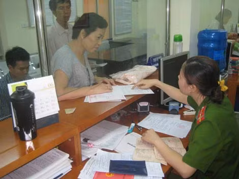 Cán bộ Công an quận Hoàn Kiếm hướng dẫn người dân kê khai hoàn thiện thủ tục đăng ký hộ khẩu thường trú.