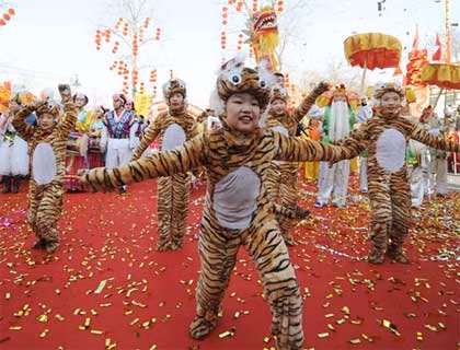 Các em bé Trung Quốc mặc đồ hình con hổ và nhảu múa mừng xuân. Trong quan niệm của người Đông phương, mỗi năm ứng với một trong số 12 con vật. Năm nay là năm của con hổ.