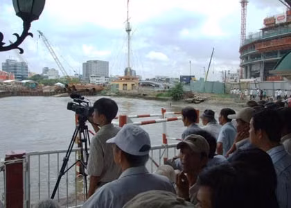 Người dân càng lúc càng dồn về một quán cà phê ven sông, phía bên quận 1 để được quan sát đốt hầm gần hơn.