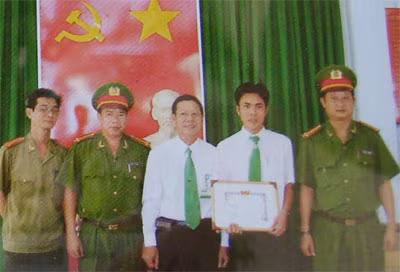 Đại diện Ban chỉ huy Công an Quận 1 thưởng nóng cho lái xe Hoàng Quốc Tuấn vì dũng cảm bắt cướp.