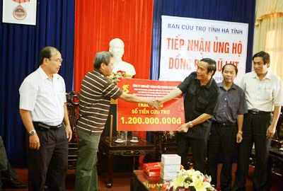 Ông Văn Thanh Liêm, Chủ tịch Hội đồng quản trị kiêm Tổng Giám đốc Công ty TNHH một thành viên Thương mại SABECO (thứ hai từ trái qua) trao số tiền cứu trợ tới ông Nguyễn Thanh Bình, Bí thư Tỉnh ủy Hà Tĩnh.