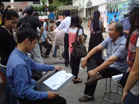 Các họa sĩ vẽ hý họa chân dung cho khán giả đến tham gia ngày hội biếm họa.