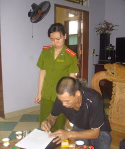 Hùng ký vào biên bản khám xét nơi ở.